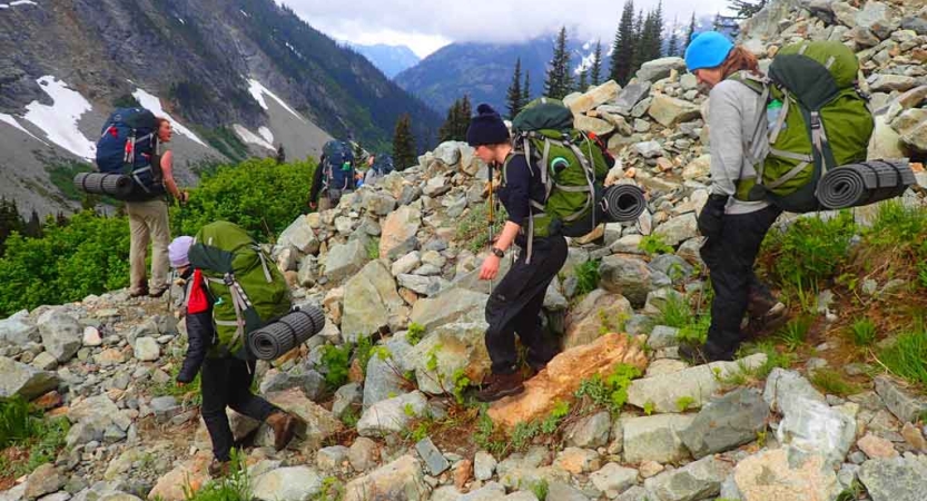a group of students descend a rocky landscape on an outward bound course